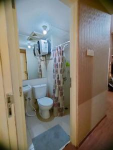 a bathroom with a toilet and a shower curtain at Tanglin Orchard Apartment (2BR) in Surabaya