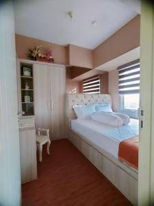 - une chambre avec un grand lit et une fenêtre dans l'établissement Tanglin Orchard Apartment (2BR), à Surabaya