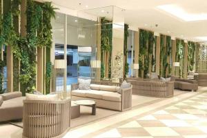 a lobby with couches and plants on the walls at Tanglin Orchard Apartment (2BR) in Surabaya