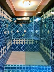 a bathroom with blue tiled walls and a shower at Sira Boutique Chiang Mai in Chiang Mai