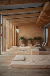 a row of beds in a room with wooden walls at Holzhotel Forsthofalm in Leogang