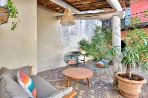 een patio met een bank, stoelen en een tafel bij La Bastideto - Piscine - AC CLim - Alpilles in Maillane