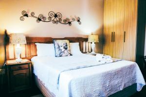 una camera da letto con un grande letto bianco con due lampade di Villa Mosaiko a Kathu
