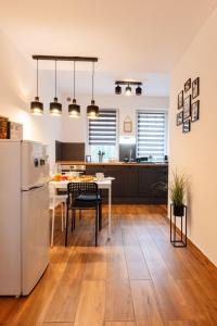 a kitchen with a refrigerator and a table with chairs at BB21 Apartman Eger - City centre in Eger