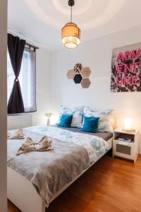 een slaapkamer met een groot bed met blauwe kussens bij BB21 Apartman Eger - City centre in Eger
