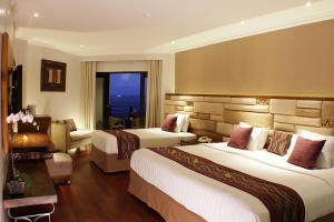 a hotel room with two beds and a window at Grand Mirage Resort & Thalasso Bali in Nusa Dua