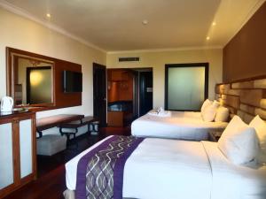 a hotel room with two beds and a desk at Grand Mirage Resort & Thalasso Bali in Nusa Dua