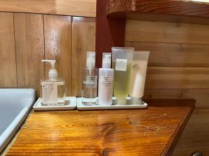 una mesa de madera con botellas de jabón y una bañera. en 高松市一軒家貸切プライベートハウスotonarisan-駐車場無料, en Takamatsu