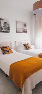 フエンカリエンテ・デ・ラ・パルマにあるApartamentos Los Volcanesのベッドルーム1室(オレンジのシーツを使用したベッド2台付)
