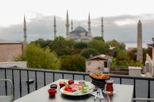 a table with a plate of food on a balcony with a mosque at HaciBayramApart in Istanbul