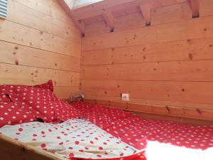 1 dormitorio con 1 cama con lunares rojos y blancos en Séjour en famille dans un chalet cosy!, en Briançon