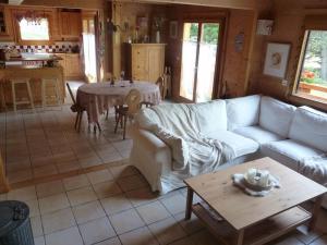 a living room with a couch and a table at Séjour en famille dans un chalet cosy! in Briançon