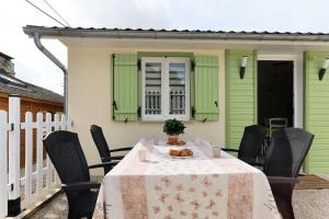 einen Tisch auf der hinteren Veranda eines Hauses in der Unterkunft La Petite Maison Du Montjard 