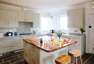 a kitchen with white cabinets and a wooden counter top at Beautiful 5-Bed House in Port Isaac in Port Isaac