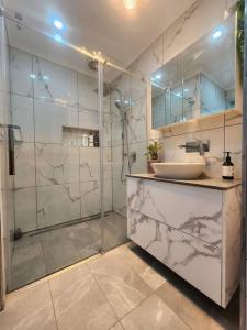 uma casa de banho com uma cabina de duche em vidro e um lavatório. em Holiday house at Trevallyn em Royal Park