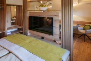 a bedroom with a fireplace with a large screen television at Appartements am Landschaweg in Weiz