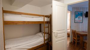 a bedroom with two bunk beds and a table at Résidence Les Arches in Saint-Lary-Soulan