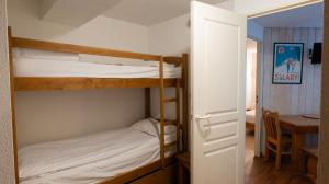 - une chambre avec 2 lits superposés et une table dans l'établissement Résidence Les Arches, à Saint-Lary-Soulan