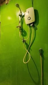a green wall with a hose hooked up to a lightswitch at Sweet jungle sea view bungalows in Sihanoukville