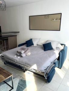 Studio Cozy avec Terrasse en centre ville ! في رواسي إن بري: سرير كبير ومخدات زرقاء عليه في غرفة