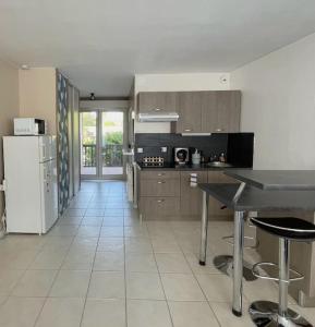 Studio Cozy avec Terrasse en centre ville ! في رواسي إن بري: مطبخ مع طاولة وثلاجة