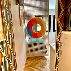 Una habitación con una puerta con un objeto colorido. en CAVALOC.FR STUDIO RETRORANGE, en Cavalaire-sur-Mer
