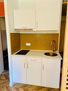 uma cozinha com armários brancos e um lavatório em CAVALOC.FR STUDIO RETRORANGE em Cavalaire-sur-Mer