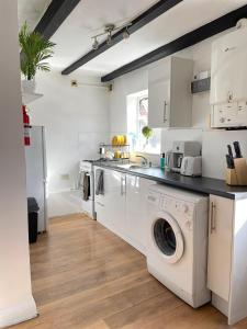 a white kitchen with a washer and dryer at Stylish One Bedroom Apartment in Oxford
