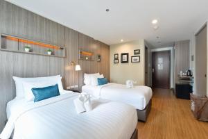 twee bedden in een hotelkamer met twee bedden bij Bedever Boutique Bangkok Hotel - BTS Phra Khanong in Bangkok