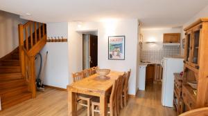 Una cocina y un comedor con mesa y sillas de madera. en Résidence Les Arches, en Saint-Lary-Soulan
