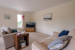 a living room with two couches and a tv at Grove Farm Bungalow and Annexe in Woodbridge