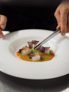 a person eating a plate of food with a fork and knife at Re Versiliana Hotel in Marina di Pietrasanta
