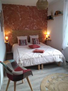 a bedroom with a bed and a chair in it at Bras de Mer in Cérans-Foulletourte