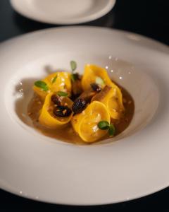 a white plate with a dish of food on a table at Re Versiliana Hotel in Marina di Pietrasanta
