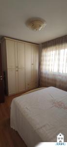een slaapkamer met een groot wit bed en een raam bij Appartamento in centro HOME in Monfalcone