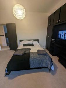 a bedroom with a large bed and a flat screen tv at Great for Short Breaks and Ideal for Contractors. in Rochdale