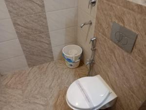 a bathroom with a toilet and a trash can at HOTEL ORCHID in Lucknow