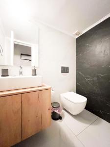 een badkamer met een wit toilet en een wastafel bij Harmonia ANhome Premium Selections in Athene