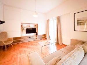een woonkamer met een bank en een tv bij Harmonia ANhome Premium Selections in Athene