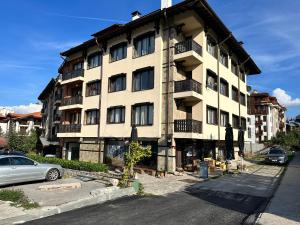 a building with a car parked in front of it at Ramada 2 - Apartment in Bansko