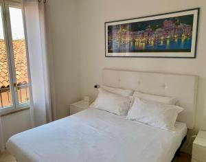 una camera da letto con un letto bianco con una foto sopra di Garibaldi18 a Desenzano del Garda