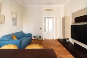 a living room with a blue couch and a television at santa tecla living faravelli 4 in Milan