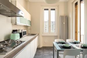 a kitchen with a stove and a table with chairs at santa tecla living faravelli 4 in Milan