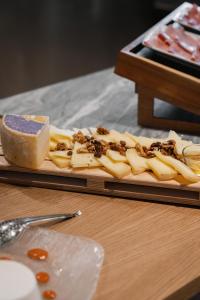 a plate of cheese and nuts on a wooden table at Re Versiliana Hotel in Marina di Pietrasanta