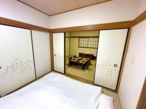 Tatami house Skytree view Asakusa line في طوكيو: اطلالة غرفة بسرير وطاولة