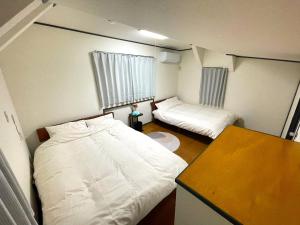 a small room with two beds and a table at Tatami house Skytree view Asakusa line in Tokyo