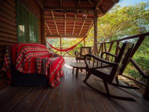a porch of a cabin with a bed and a bench at 2 bedroom cottage, 3 blocks from beach and center of San Juan in San Juan del Sur +15 photos