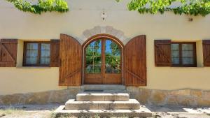 una entrada a una casa con puertas de madera en La Calma Montblanc Prenafeta, en Prenafeta