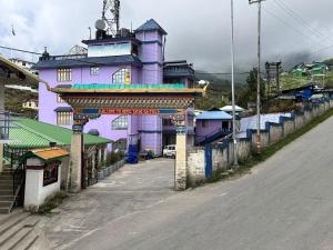 a purple building on the side of a street at Hotel Tashi Ga Tsel in Tawang