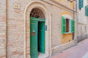 a green door on the side of a brick building at Leone Acciaioli - YourPlace Abruzzo in Ortona